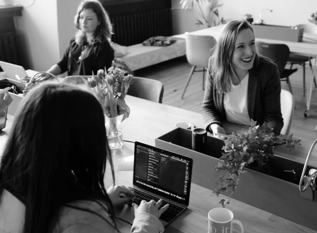 Ladiessitting at a desk.